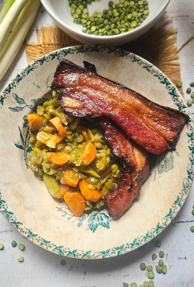 Poêlée de pois cassés aux carottes et poireaux crayons, servie avec du lard grillé
