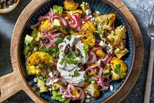 Chou-fleur rôti au curry et avocat en salade, servi avec une sauce au yaourt tahini