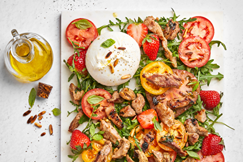 Salade d’émincés d’agneau à la burrata, fraises, tomates anciennes et crème de balsamique