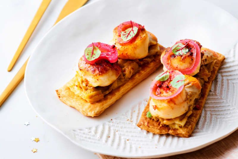 Tartelettes fines aux noix de saint Jacques, fondue de poireaux et pickles d’oignons rouges