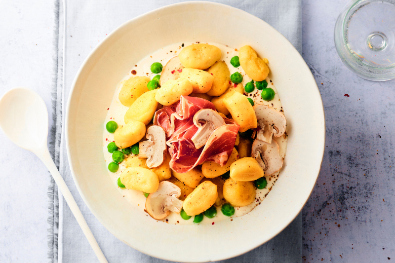 Gnocchi de purée Mousline à la crème au vin blanc, petits pois, jambon de Parme et champignons crus