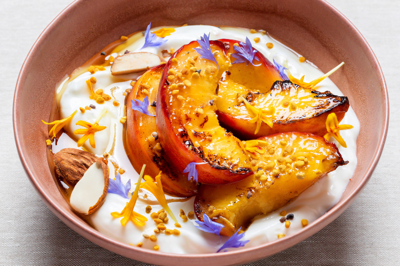 Pêches poêlées, skyr à la fleur d’oranger et amandes grillées