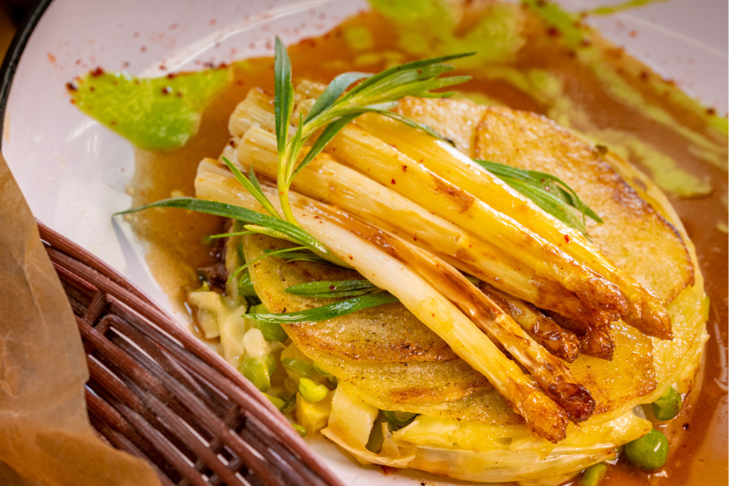 Gratin d’asperges de France, pommes de terre nouvelles, petits pois et brie, sauce rhubarbe