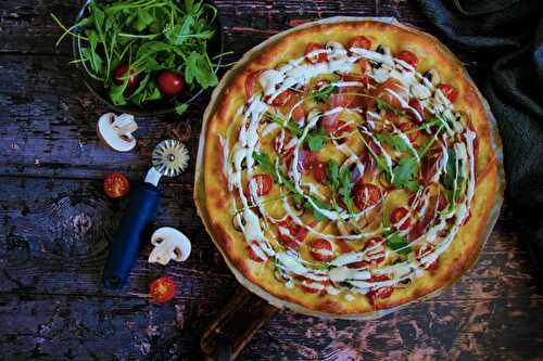 Pizza blanche aux tomates cerises, jambon de parme, champignons et roquette