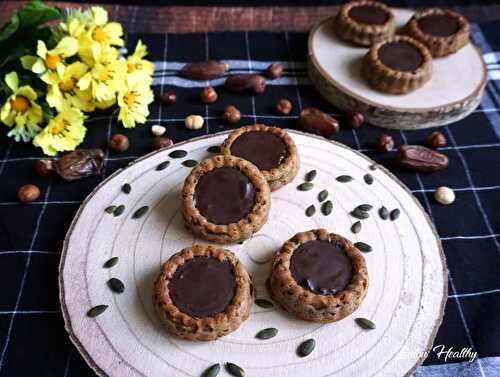 Tartelettes noisette-courges fourrées pâte à tartiner noisettes-dattes & nappées chocolat dattes, graines de courge, sésame toasté {Vegan}