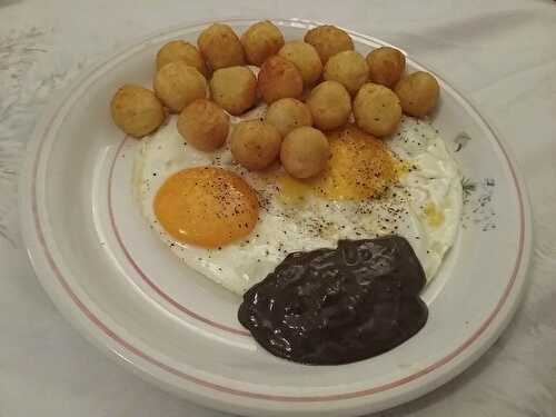 Œufs sur le plat et pommes dauphines à la crème d’ail noir