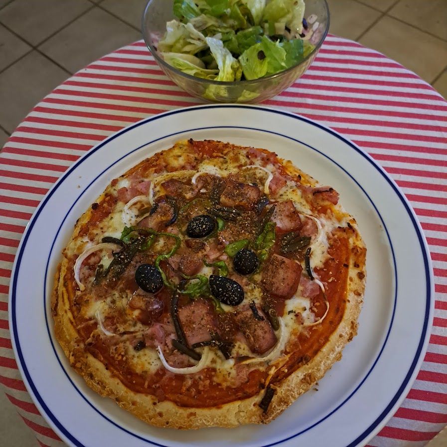 Pizza de lard aux poivrons verts et aux olives noires et vinaigrette à l’ail noir