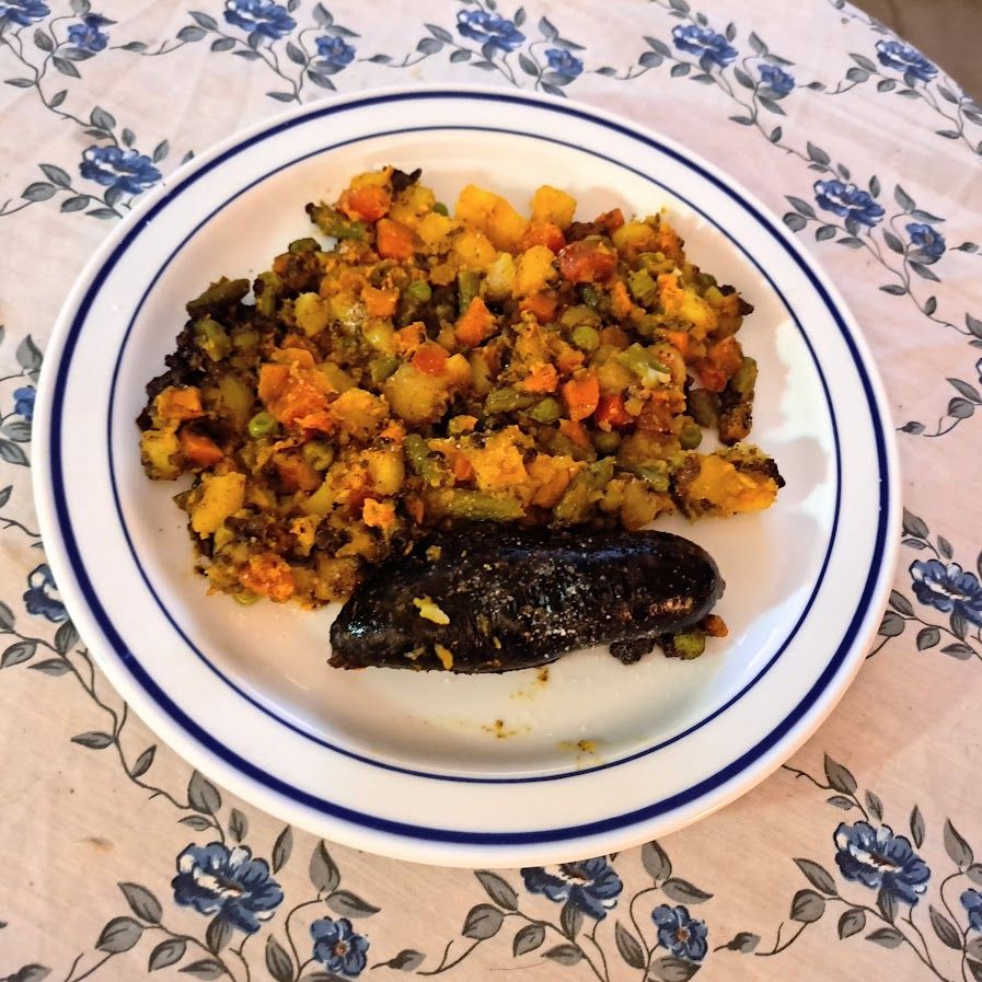 Boudins noirs et macédoine de légumes au curry et à l’ail noir