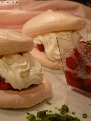 Framboises gourmandes sur nid de meringues roses, poudre de pistaches...