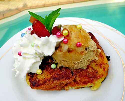 Brioche perdue caramélisée à la Plancha, couronnée d'une boule de glace au caramel, de fruits confits et de crème fouettée