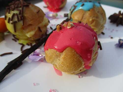 Mini choux fourrés à la crème, couverts d'un glaçage de couleur