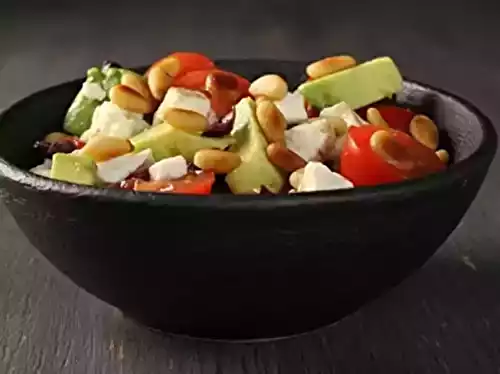 Salade d'avocats avec feta, pignons, tomates et olives noires