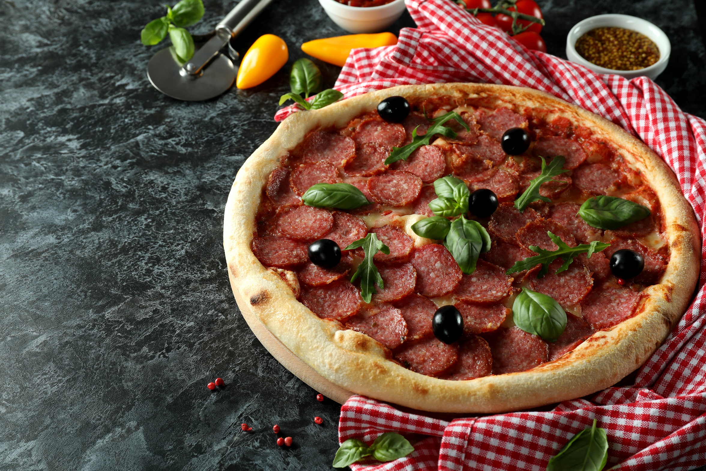 Pizza traditionnelle au salami sur lit de sauce tomate, mozzarella fondante et huile d'olive parfumée