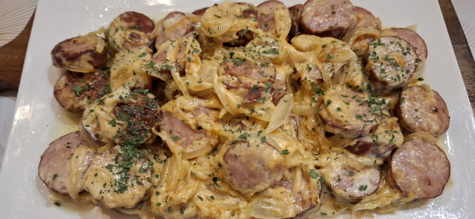 Saucisses de Montbéliard mijotées à  la sauce moutarde et aux oignons